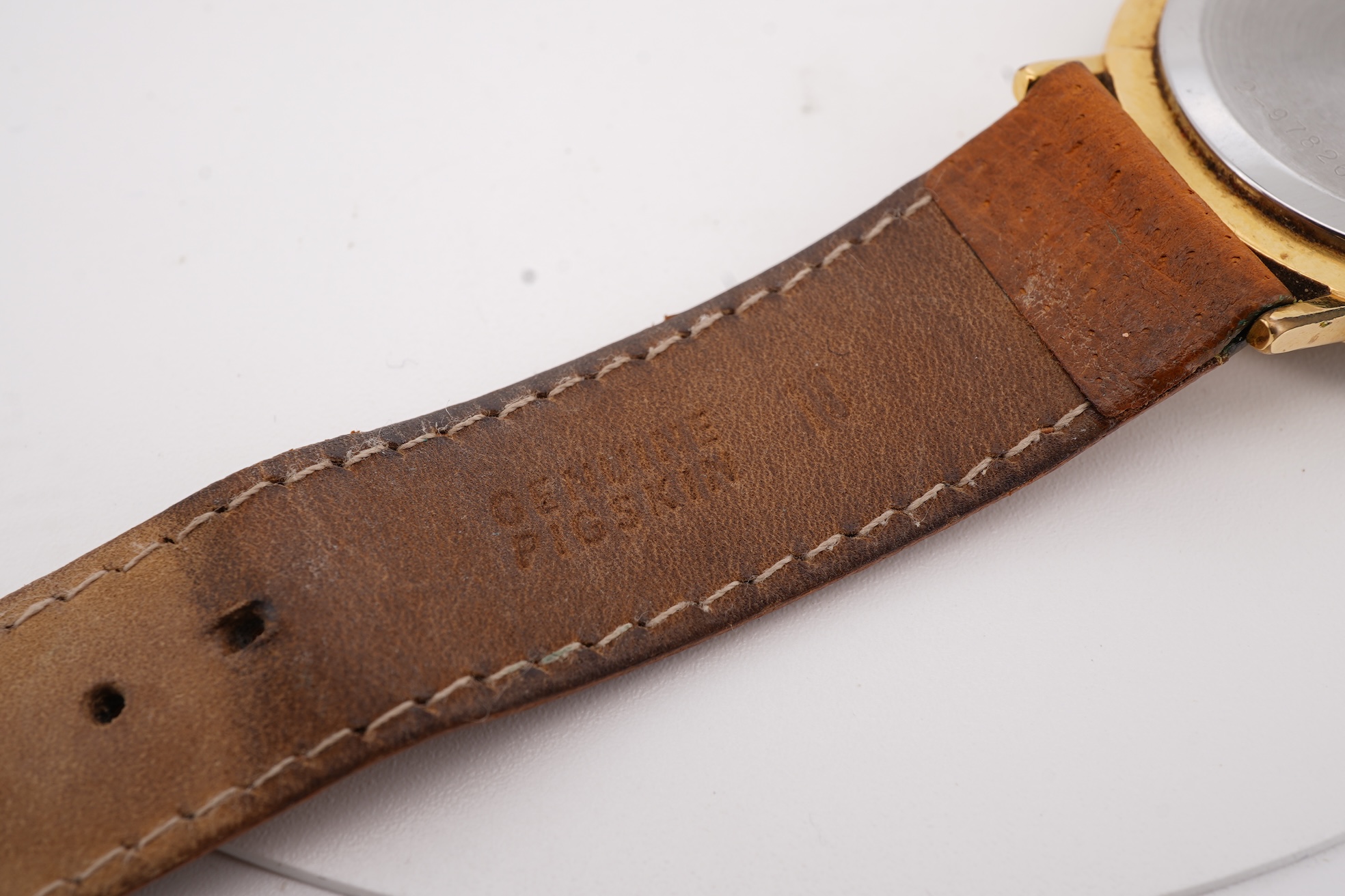 A gentleman's steel and gold plated Bulova Longchamp manual wind wrist watch, with baton numerals, case diameter 33mm, on a tanned leather strap.